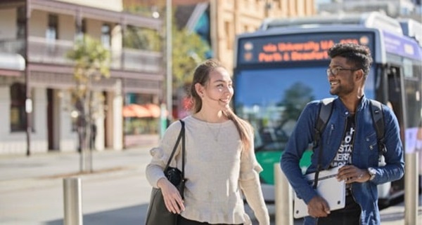 2 students walking away from a bus