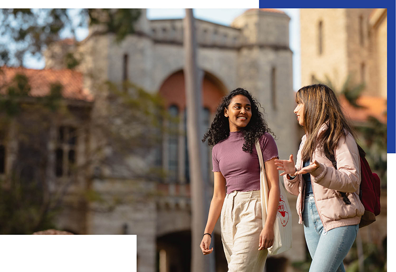 Two students walking and talking outside Winthrop Hall